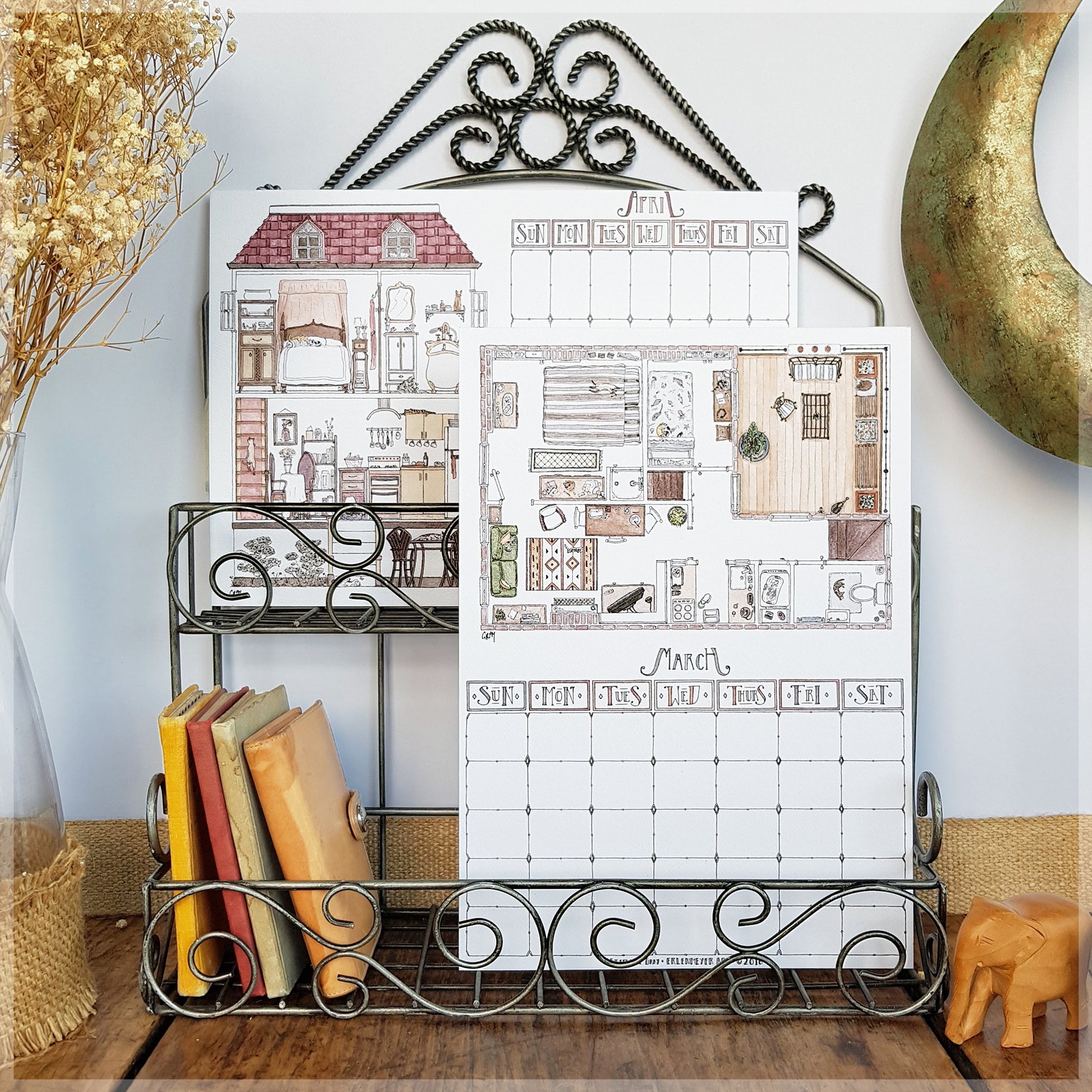 Erlenmeyer cat calendar showing the months of March and April, displayed on a wire frame display rack.