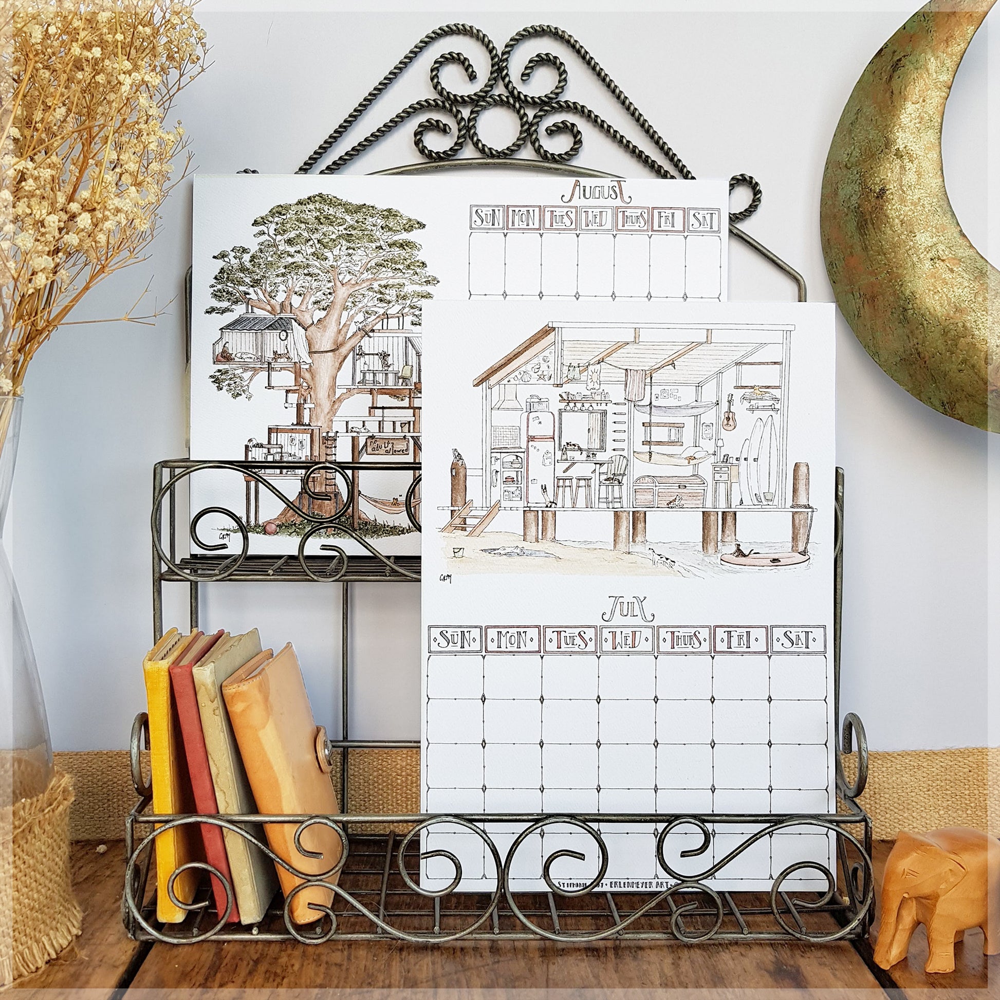 Erlenmeyer cat calendar showing the months of August and July , displayed on a wire frame display rack.