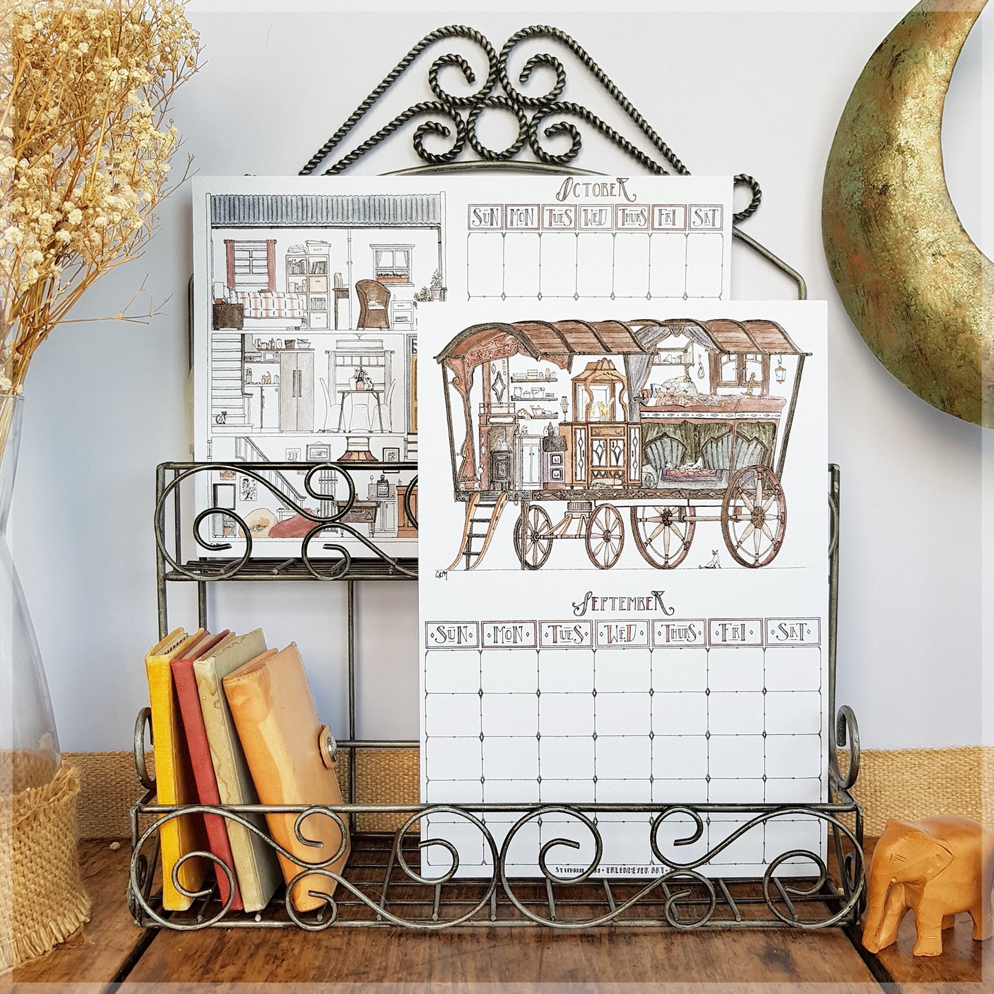 Erlenmeyer cat calendar showing the months of October and September mounted on a wire frame display rack.