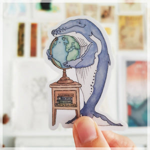 Blue the whale hugging the globe and dreaming about the next holiday she wants to go on.